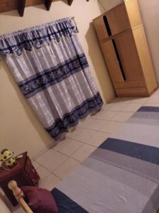 une chambre avec un rideau dans une chambre avec une porte dans l'établissement Haus Independencia Guara Paraguay, 