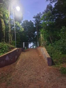 a dirt road with a street light and trees at Haus Independencia Guara Paraguay 