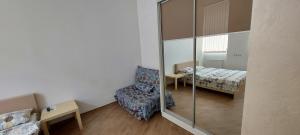 リヴィウにあるApartments in Lembergの鏡、椅子、ベッドが備わる客室です。