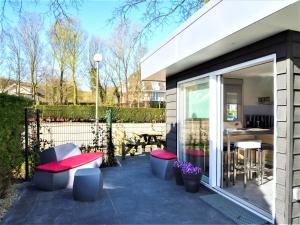 un patio con bancos, mesa y sillas en Vakantiehuis Zee, Bos & Duin Zoutelande ZO01, en Zoutelande