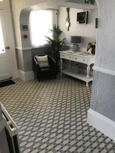 a room with a table and a chair and a desk at The Denewood in Sandown