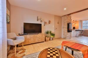 a living room with a flat screen tv on a cabinet at Au nid douillet in Metzeral