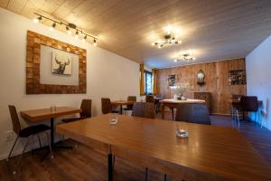 a dining room with wooden tables and chairs at Room's chez BeNi in Grächen