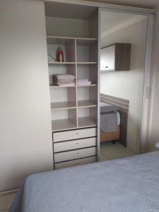 a bedroom with a closet with a bed and a mirror at Apto Aconchego da Serra - Bairro Maria Goretti in Bento Gonçalves