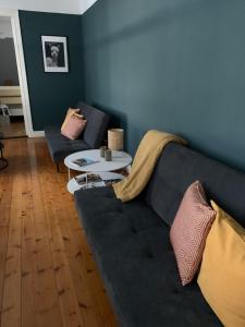a living room with a couch and a table at Tree Top Hill - The Old Station House - Båstad Holiday Apartments in Båstad