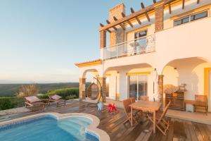 a villa with a swimming pool and a house at Arrifana Destination Suites in Aljezur