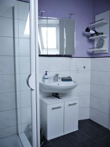 a white bathroom with a sink and a shower at Gästehaus AM HERMANN in Hörstel