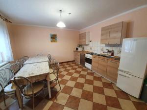 uma cozinha com uma mesa e cadeiras e um frigorífico em Noclegi pod Klimczokiem em Bystra