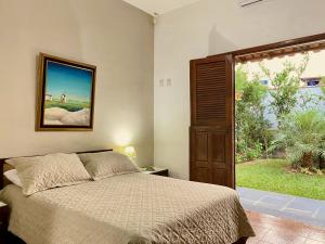 a bedroom with a bed and a large window at Pousada Nossa Terra in Rio Novo