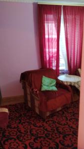 Zimmer mit einem Bett und einem Fenster mit roten Vorhängen in der Unterkunft Одесская квартира в центре in Odessa
