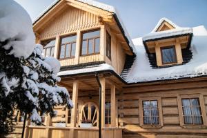 a log cabin in the snow at Apartamenty Stare Izby in Poronin