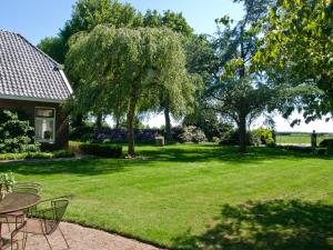 une cour avec des tables et des chaises et un arbre dans l'établissement Landgoed Wittelte Dwingeloo, à Wittelte 66 autres photos
