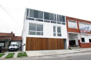 a white building with windows and a wooden door at PH Mogotes in Mar del Plata