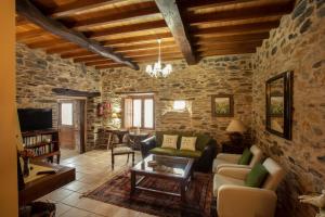 a living room with a stone wall at Lugar del Rio in Couzadoiro