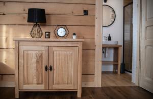 Apartamenty Stare Izby في بورونين: خزانة خشبية عليها ساعة في الغرفة