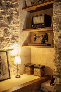 a room with a table with a lamp and a radio at Lugar del Rio in Couzadoiro