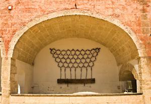 an archway in a brick wall with a metal object at Masseria Spina Resort in Monopoli