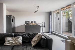 a living room with a black couch and a kitchen at Steg 1 in Moos