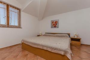 a white bedroom with a bed and a window at Apartments Villa Estella in Srima