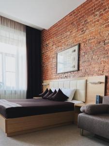 Un dormitorio con una pared de ladrillo y una cama grande en Center Hotel, en San Petersburgo