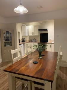 a kitchen with a wooden table and white chairs at Church Farm, Legbourne Louth in Legbourne