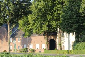 un grand bâtiment en briques avec une porte. dans l'établissement Gästezimmer Bergerhof - Ankommen und Wohlfühlen, à Neuss