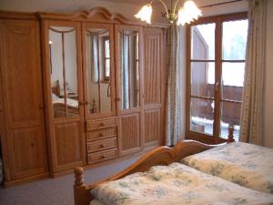 1 dormitorio con 2 camas, armarios de madera y ventana en Ferienwohnung Wiesenleiten, en Ruhpolding