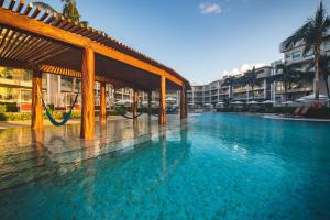 una piscina con una hamaca en un complejo en Dreams Jade Resort & Spa - All Inclusive, en Puerto Morelos