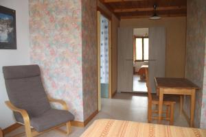 a living room with a chair and a table at Le Vieux Chalet in Embrun