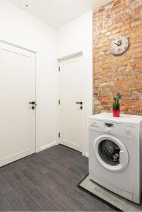 a washing machine in a laundry room with a brick wall at Aparthotel ЦЕНТР у Центрального Вокзала Минск-Пассажирский in Minsk