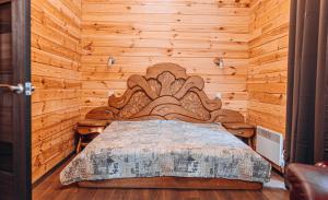 a bedroom with a bed in a wooden wall at Log House Savin in Savin