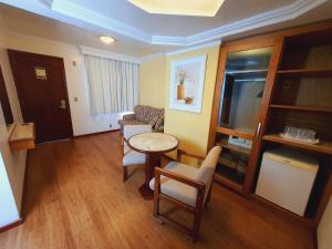 a living room with a table and chairs at Jandaia Turismo Hotel in Santana do Livramento