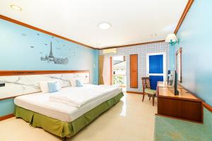 a large bedroom with a large bed and a desk at Mayfa Hotel - SHA extra plus in Phuket