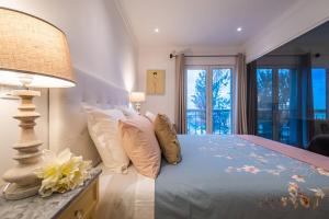 フンシャルにあるFunchal Center Apartment Iの枕とランプが付いたベッドのある寝室