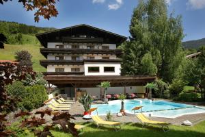 un complexe avec une piscine et un bâtiment dans l'établissement Altachhof Hotel und Ferienanlage, à Saalbach-Hinterglemm