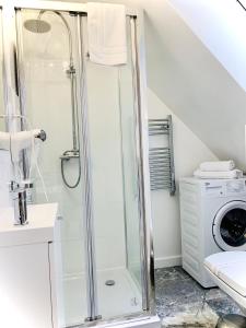 a bathroom with a shower and a washing machine at Apartamenty VIP in Ustka