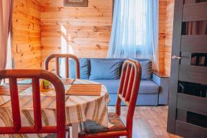 a living room with a table and a blue couch at Log House Savin in Savin