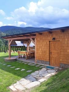 einem Holzschuppen mit einem Picknicktisch und einer Bank in der Unterkunft Desný Kout in Kouty