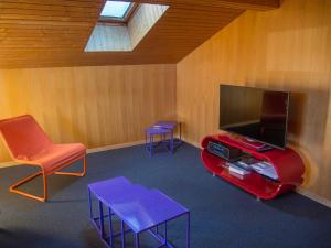 アデルボーデンにあるIm Zentrum OGのテレビ、椅子2脚、テーブルが備わる客室です。