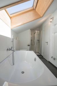 eine weiße Badewanne im Bad mit Dachfenster in der Unterkunft Im Zentrum OG in Adelboden