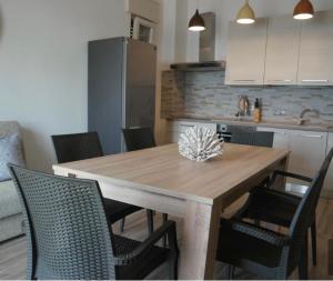 cocina con mesa de comedor de madera y sillas en ATTICO GALILEI D. en Gallipoli