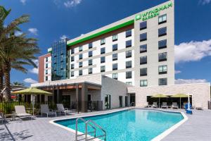 un hôtel avec une piscine en face d'un bâtiment dans l'établissement Wyndham Garden Orlando Universal / I Drive, à Orlando