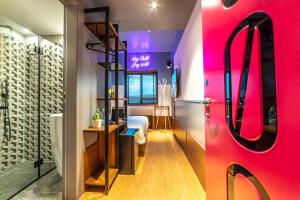 a bathroom with a red door and a room with a bed at Stay Inn Hotel Jerusalem in Jerusalem