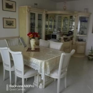 una sala da pranzo con tavolo e sedie bianche di Rossyiva a Minturno