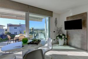 ein Wohnzimmer mit einem Tisch und Stühlen sowie einem Balkon in der Unterkunft La Castellana Superior Apartments in Sirmione
