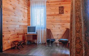 a room with two chairs and a desk with a television at Log House Savin in Savin