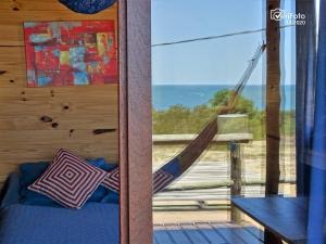 Una habitación con hamaca y vista al mar. en OHANA, en Punta del Diablo