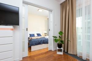 1 dormitorio con 1 cama y TV de pantalla plana en Royal City Center Mennica Residence by Renters, en Varsovia