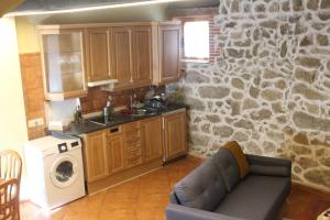 cocina con sofá y pared de piedra en La Ribera de Gredos 