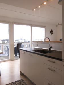 een keuken met een wastafel en een groot raam bij ApartmentInCopenhagen Apartment 427 in Kopenhagen